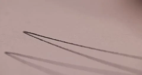Drawing with a black pencil on paper close up, drawing on paper with a wooden Stock Footage 324876904