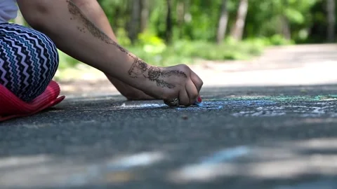 Drawing with chalk on asphalt in the park Stock Footage 90984986