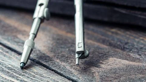 Drawing compass on drawing table and table Фото