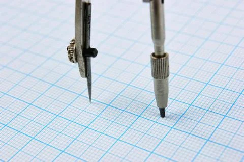 Drawing compass on graph paper Fotos de archivo