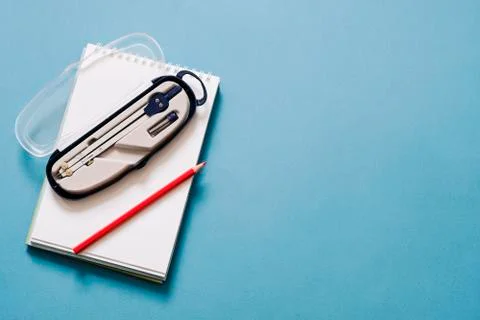 Drawing Compass, notepad and pencil isolated on blue background, copy space Stock Photos