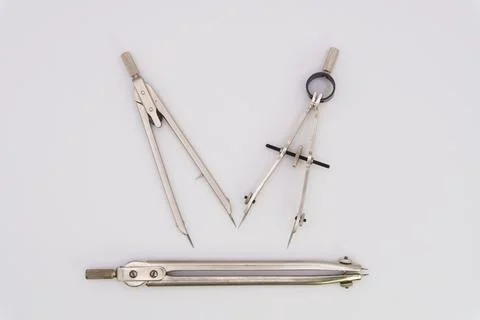 Drawing compass on a white background made of silver-colored metal Fotos de archivo