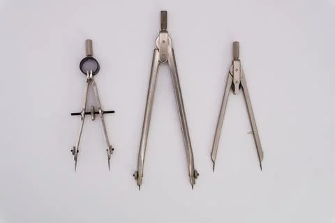 Drawing compass on a white background made of silver-colored metal Fotos de archivo