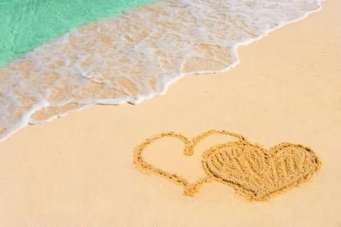 Drawing connected hearts on beach Stock Photos