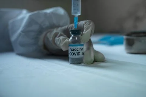 Drawing covid 19 vaccine from vial into syringe for vaccination Stock Photos