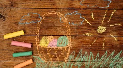 Drawing with crayons on a wooden background. Easter eggs in a basket Stock Photos