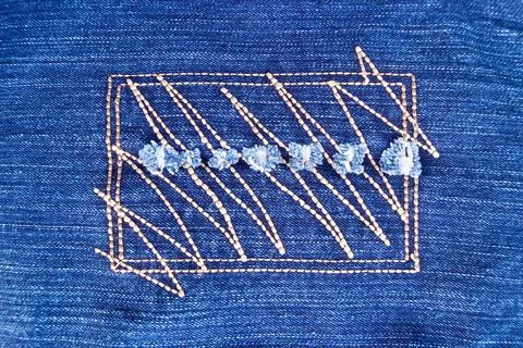 Drawing on denim Abstract pattern embroidered on denim in the form of a re... Stock Photos