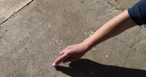 Drawing different elements on a concrete road with children's crayons, an adult Stock Footage 324685731