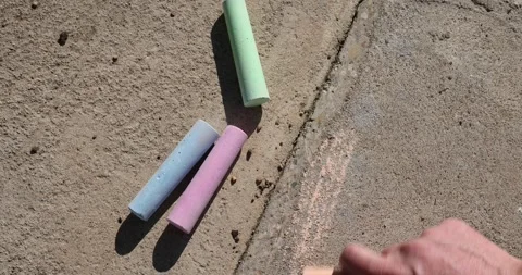 Drawing elements on a concrete road with colorful children's crayons, an adult 스톡 동영상 324877079