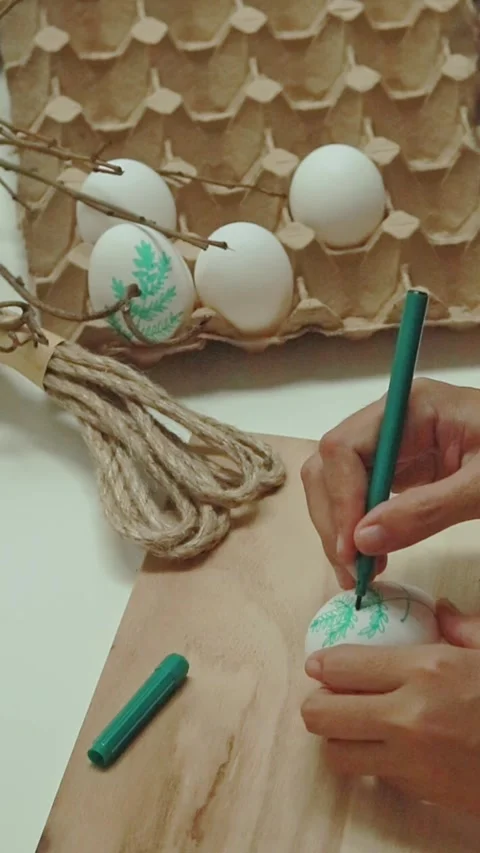 Drawing a fern leaf pattern using green marker pen to design an easter egg Stock Footage 307047228