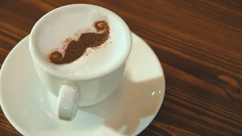 Drawing on the foam of coffee or latte art in the form of a mustache close Stock Footage 102802201