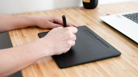 Drawing on a graphics tablet. Close-up of hands and tablet. Stock Footage 180959407