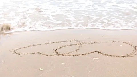 Drawing hart on beach 스톡 동영상 73714265