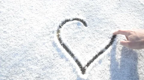 Drawing a heart shape on snow with a finger Stock-Footage 45870962