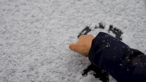 Drawing heart shape on snowy surface, 4k slow motion Stock Footage 255021738