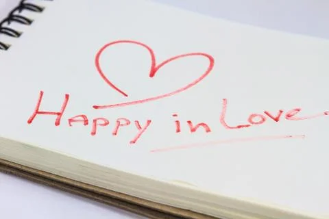 Drawing heart on white notebook Stock Photos