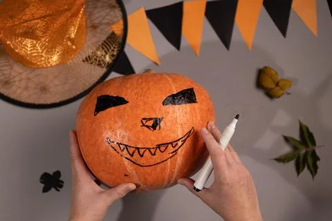 Drawing a Jack Olantern Face on a Pumpkin for Halloween at Home Stock Photos
