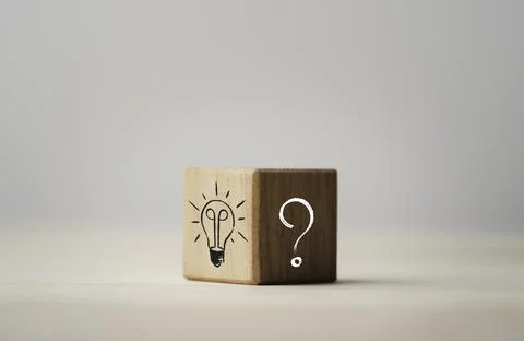 Drawing of light bulb on bright side and question mark on dark side of wooden Stock Photos