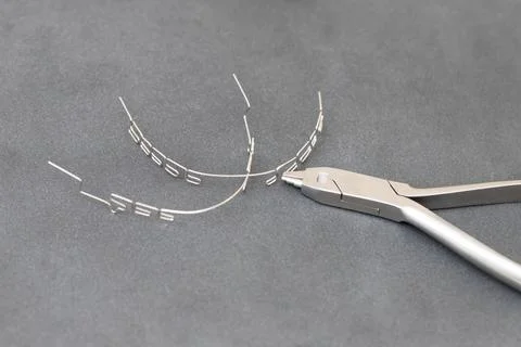 Drawing up a multiloop ortho-arc on a gray background in a special tool Stock Photos