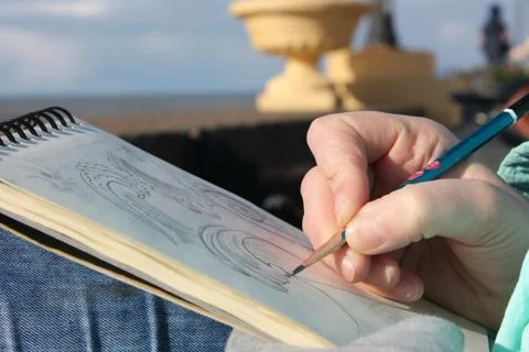 Drawing in a notebook on the waterfront Stock Photos