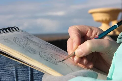 Drawing in a notebook on the waterfront Stock Photos