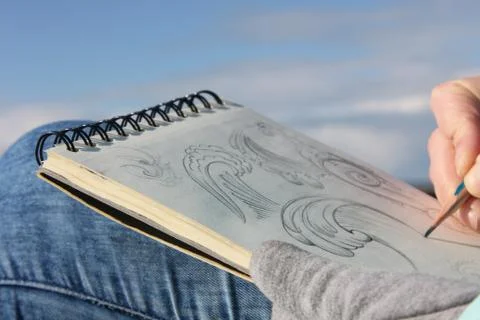 Drawing in a notebook on the waterfront Stock Photos