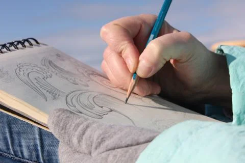 Drawing in a notebook on the waterfront Stock Photos