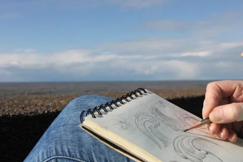 Drawing in a notebook on the waterfront Stock Photos