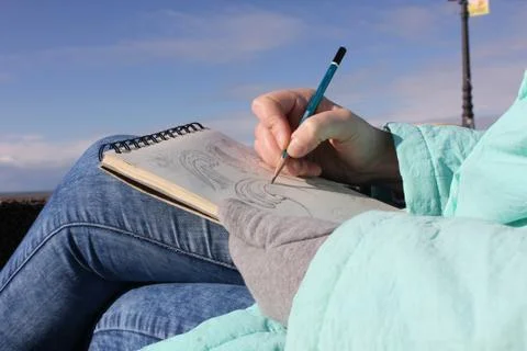 Drawing in a notebook on the waterfront Stock Photos