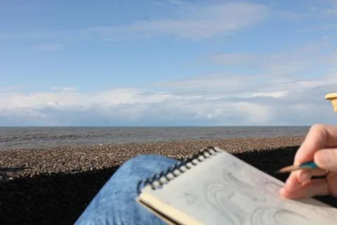 Drawing in a notebook on the waterfront Stock Photos