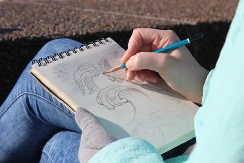 Drawing in a notebook on the waterfront Stock Photos