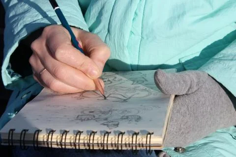 Drawing in a notebook on the waterfront Stock Photos