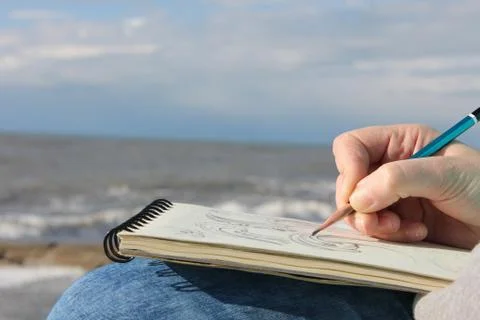 Drawing in a notebook on the waterfront Stock Photos