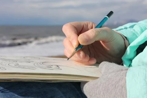 Drawing in a notebook on the waterfront Stock Photos