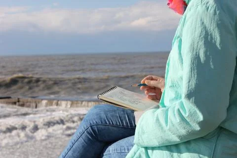 Drawing in a notebook on the waterfront Stock Photos
