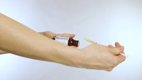 Drawing out liquid medication with a shake well label Stock Footage 72752401