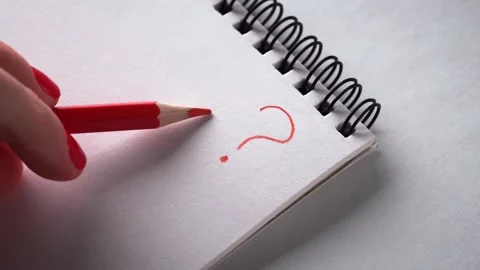 Drawing a Question Mark with Red Pencil on White Notebook Stock Footage 301469376