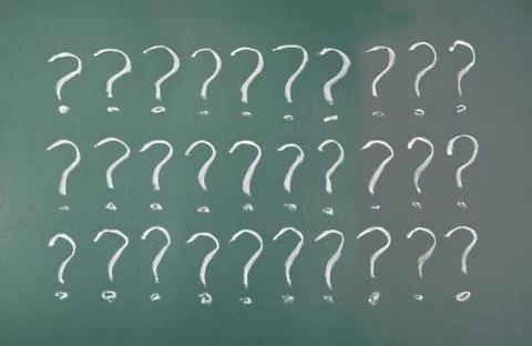 Drawing question marks on blackboard. Stockfoto's