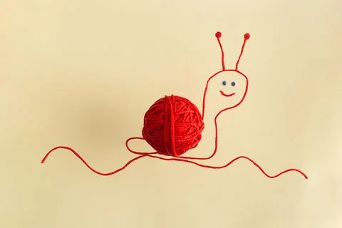 Drawing of red snail from wool threads with ball integrated knitting creative Stock Photos