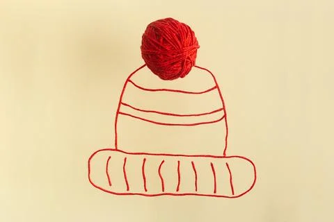 Drawing of red winter hat from wool threads with ball integrated knitting Stock Photos