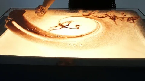 Drawing with sand. Drawing sand on a white screen. Sand Artist. Hands draws Stock Footage 89612428