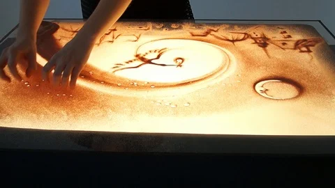 Drawing with sand. Drawing sand on a white screen. Sand Artist. Hands draws Stock Footage 89612474