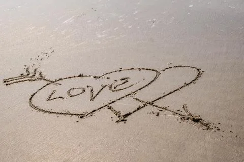 Drawing in sand in form of two hearts and inscription love Stock-Fotos
