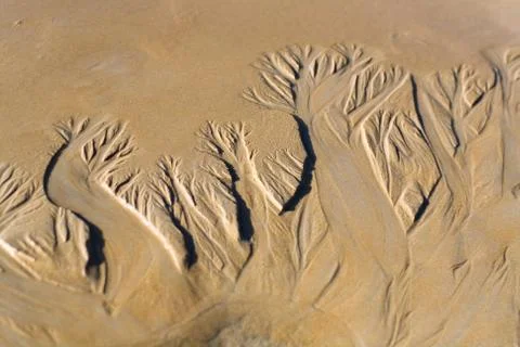 Drawing on the sand made by a stream. Stock Photos