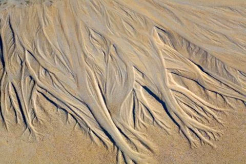 Drawing on the sand made by a stream. Stock Photos