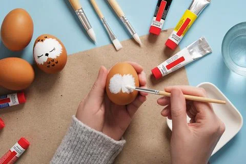 Drawing a sleeping owl on an eggshell. Step 1: Draw the owl's white face. P.. Stock Photos