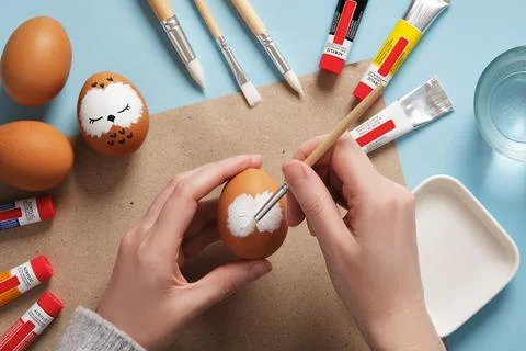 Drawing a sleeping owl on an eggshell. Step 1: Draw the owl's white face. P.. Stock Photos