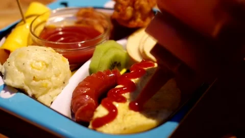 Drawing smiling face squeezing ketchup on Omurice lunchbox omelette rice Stock Footage 263965922