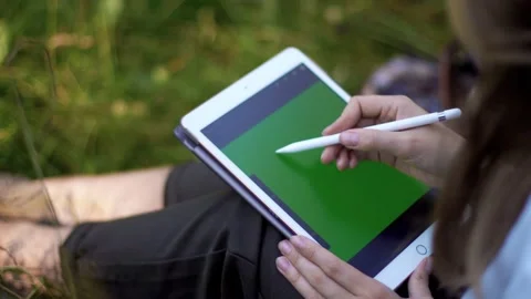 Drawing on a tablet in nature. green screen Stock Footage 231258481