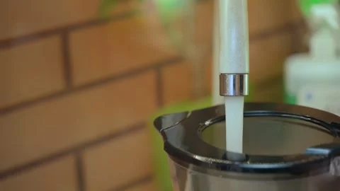 Drawing water from a tap into a filter, close-up Stock Footage 324518335
